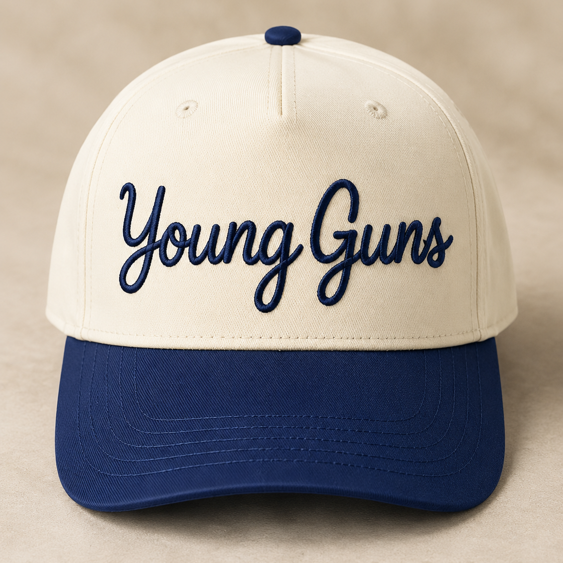 Cream and navy baseball hat embroidered with Young Guns in navy script