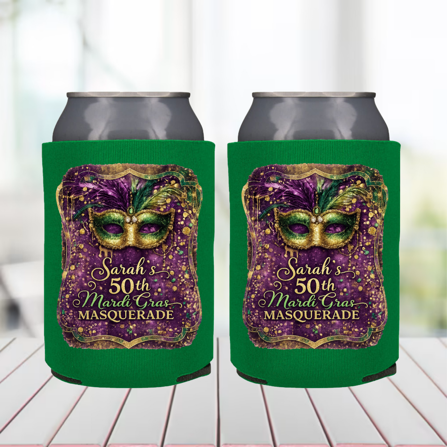 Two green can coolers with a Mardi Gras mask design and text on a white surface.
