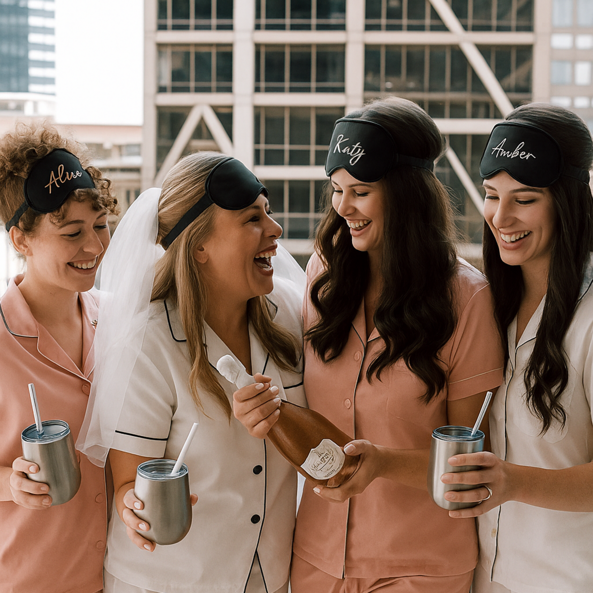 Four women in matching pajama sets and sleep masks with names on them, standing together.