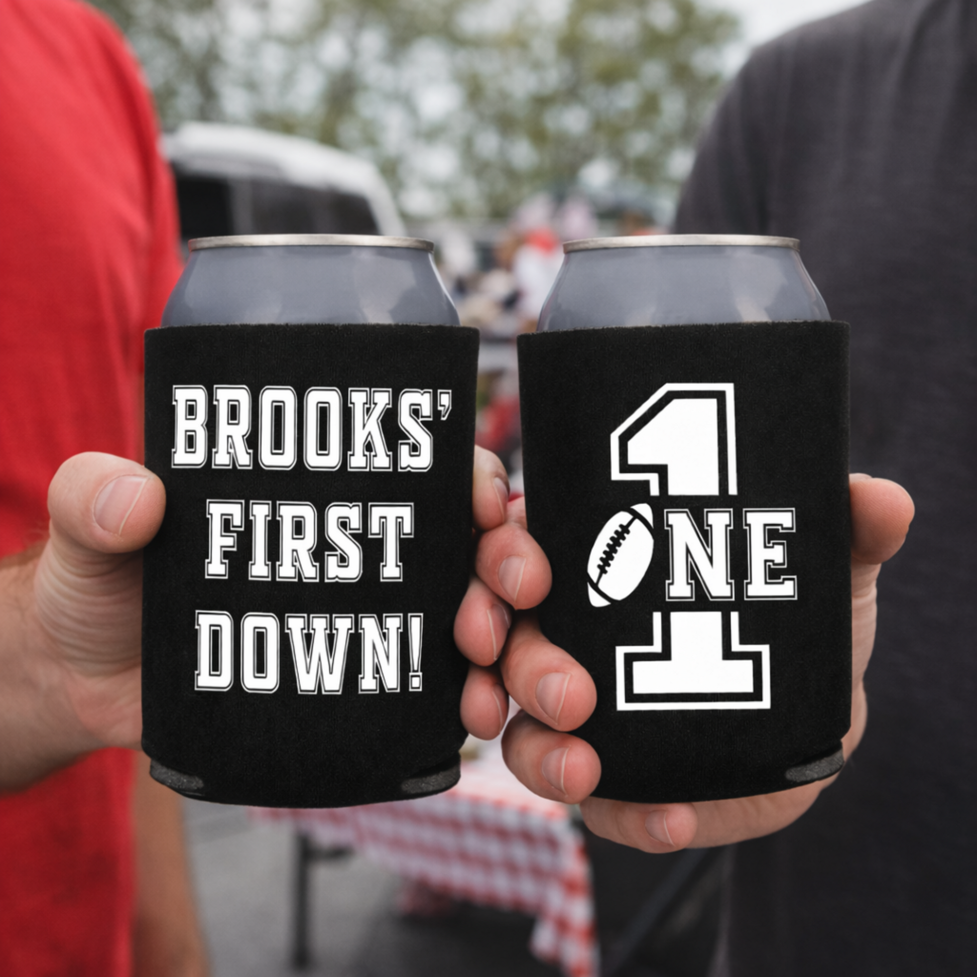 Two can coolers with personalized designs held by two people, one with 'Brooks' First Down!' and the other with '411'.