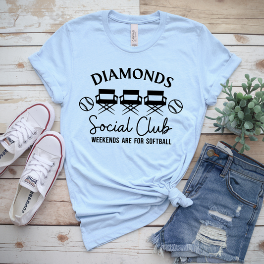 Light blue t-shirt with 'Diamonds Social Club' text, paired with denim shorts and sneakers on a wooden surface.