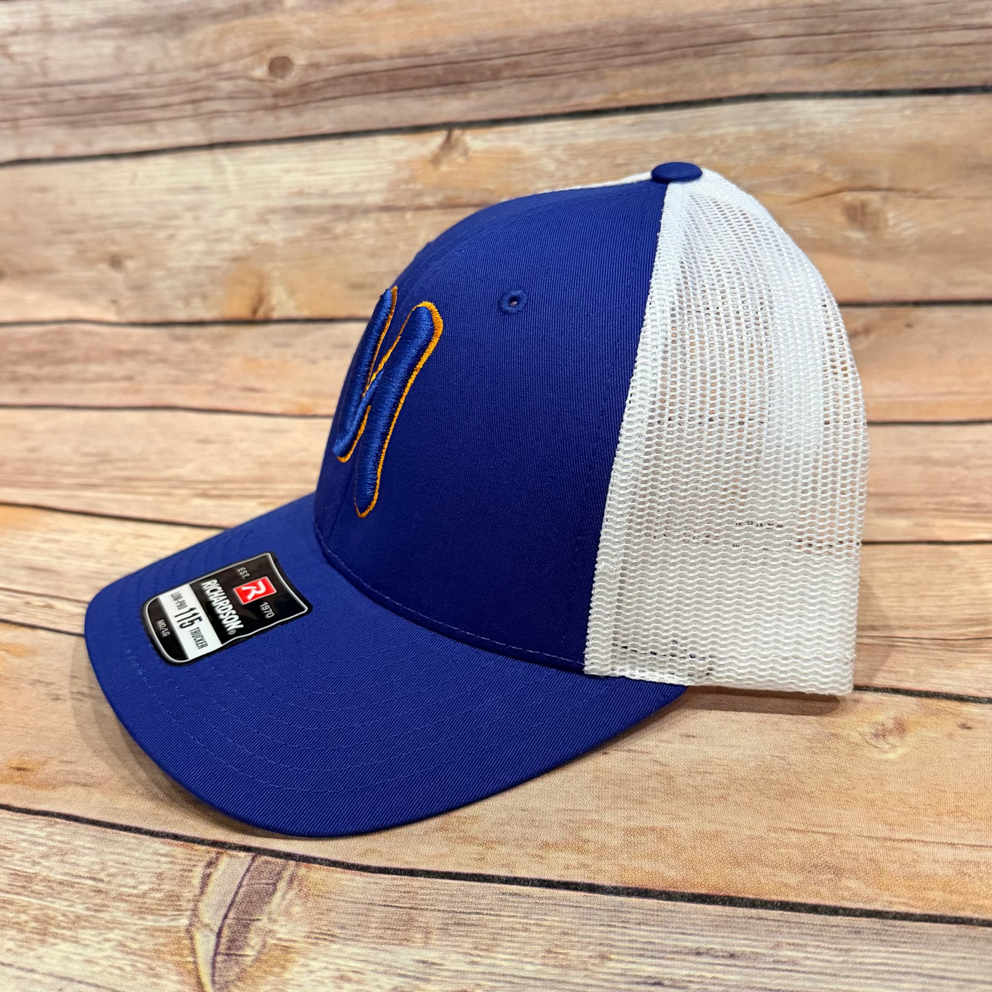 Blue and white baseball cap with a logo on a wooden surface