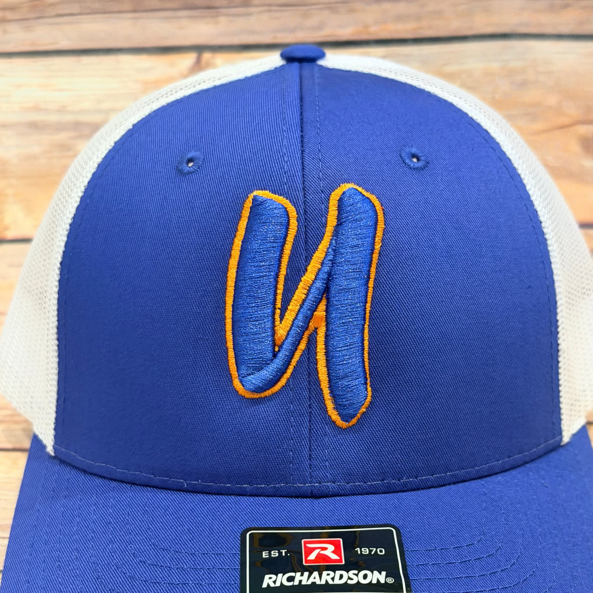 Blue and white cap with a logo on a wooden surface