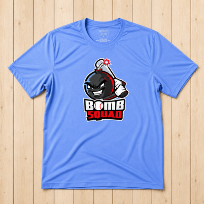 A light blue short-sleeve t-shirt with a cartoon bomb graphic and the words 'BOMB SQUAD' printed on the front, laid flat on a light wood plank background.