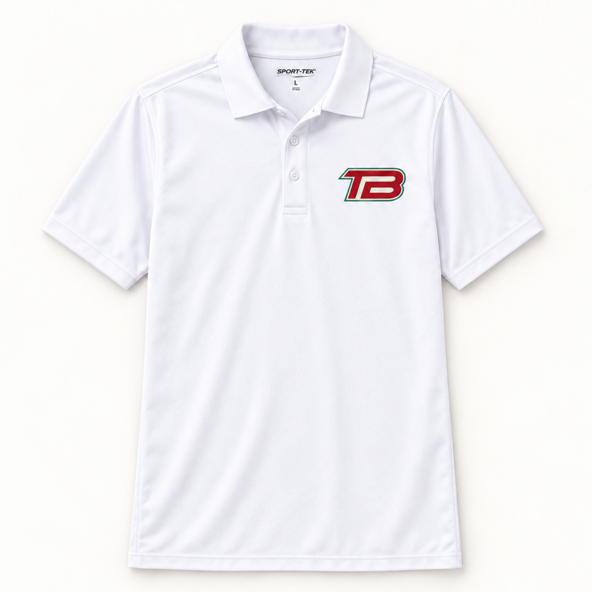 A white short-sleeve polo shirt with a collar and a three-button placket, featuring a red and black 'TB' logo on the left chest. The brand 'SPORT-TEK' is visible on the inner neck label.