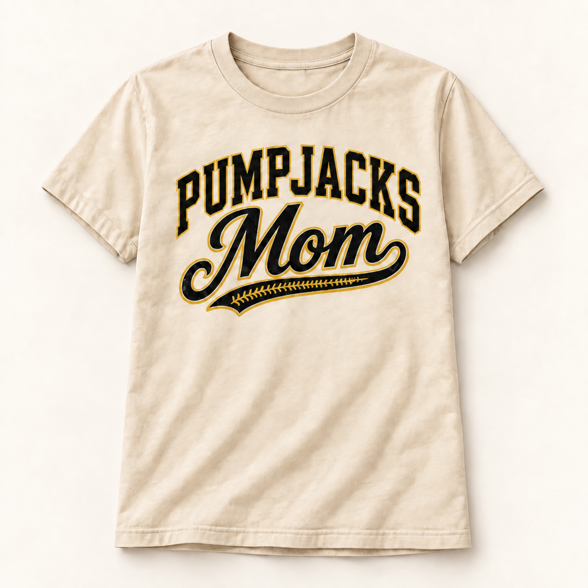 A beige short-sleeve t-shirt with 'Pumpjacks Mom' printed on the front in black and gold varsity-style lettering, displayed against a clean off-white background.