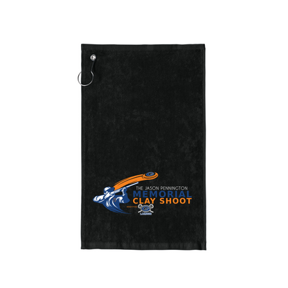 A black golf towel with a metal hanging loop at the top left, featuring a printed 'The Jason Penninton Memorial Clay Shoot' logo in blue, orange, and white near the bottom center.