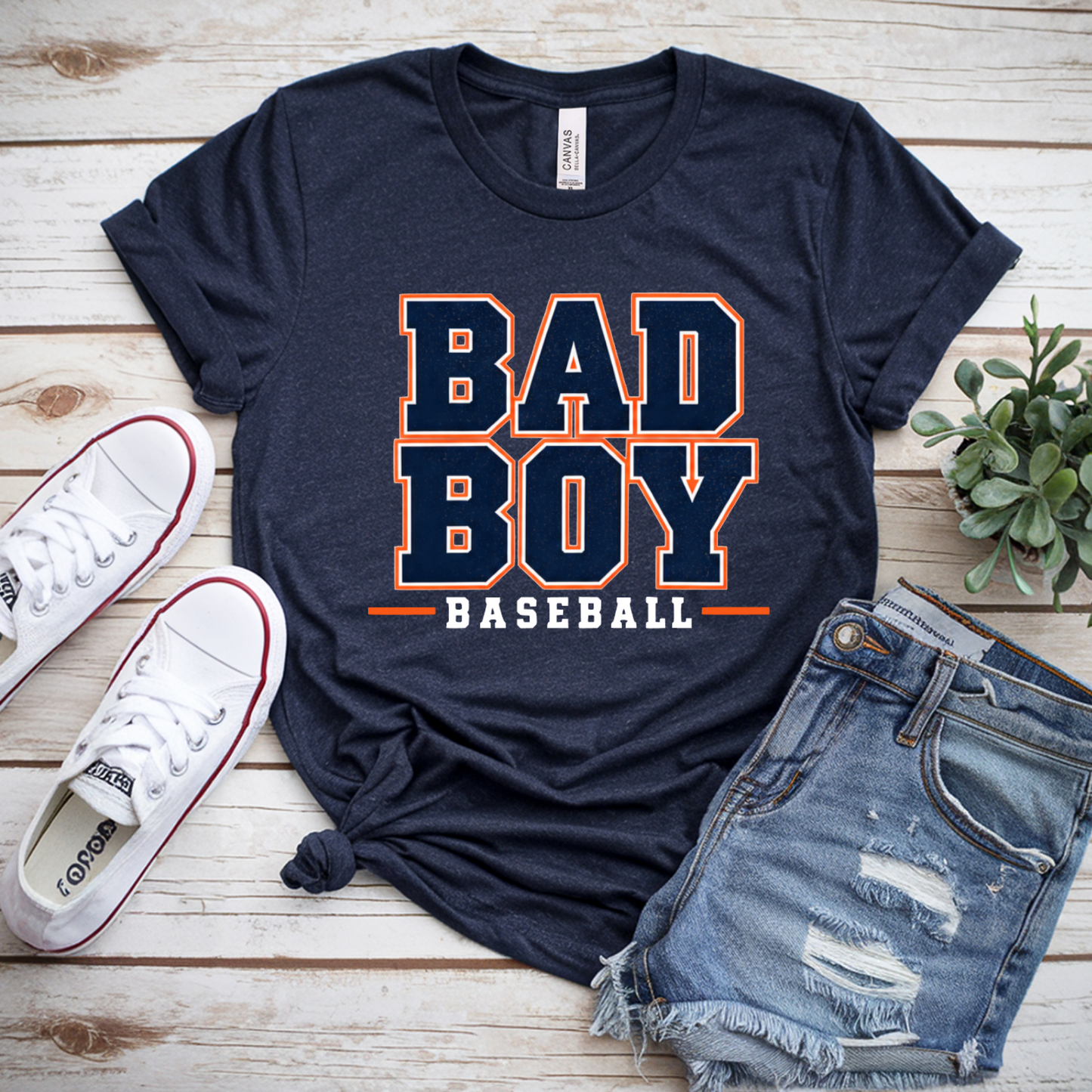 Bad Boy Baseball navy shirt with orange white and navy varsity lettering
