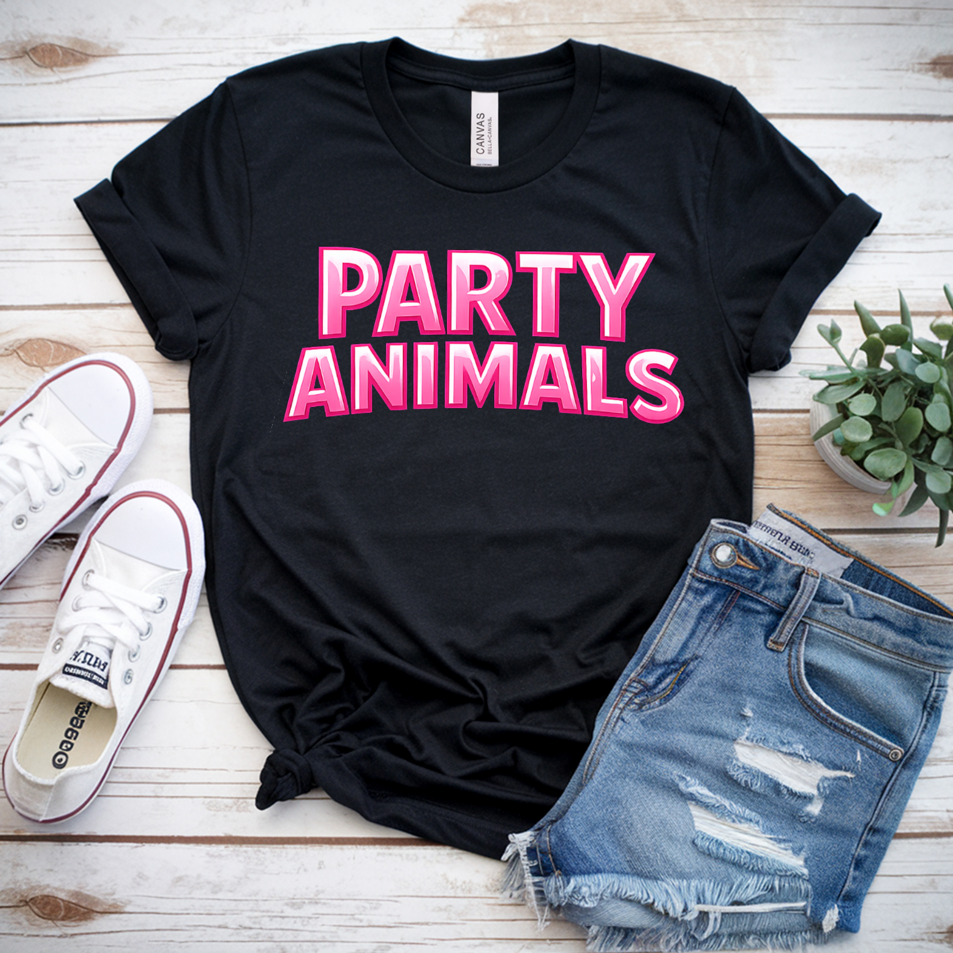 Black t-shirt with 'PARTY ANIMALS' text, white sneakers, denim shorts, and a plant on a wooden surface.