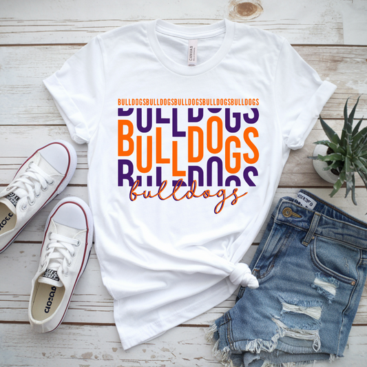 White t-shirt with 'Bulldogs' text, white sneakers, denim shorts, and a plant on a wooden surface.