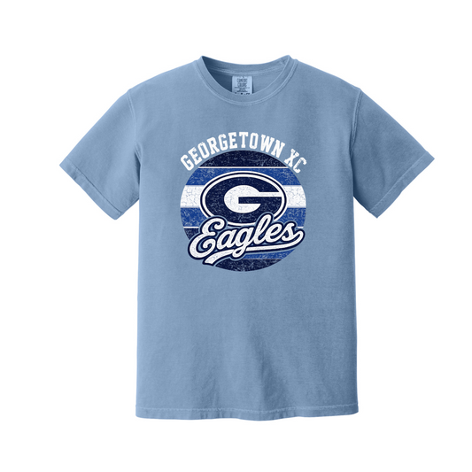 A light blue short-sleeve t-shirt with a distressed graphic on the front featuring the text 'GEORGETOWN XC' and 'Eagles' around a large letter 'G' logo, displayed on a solid white background.