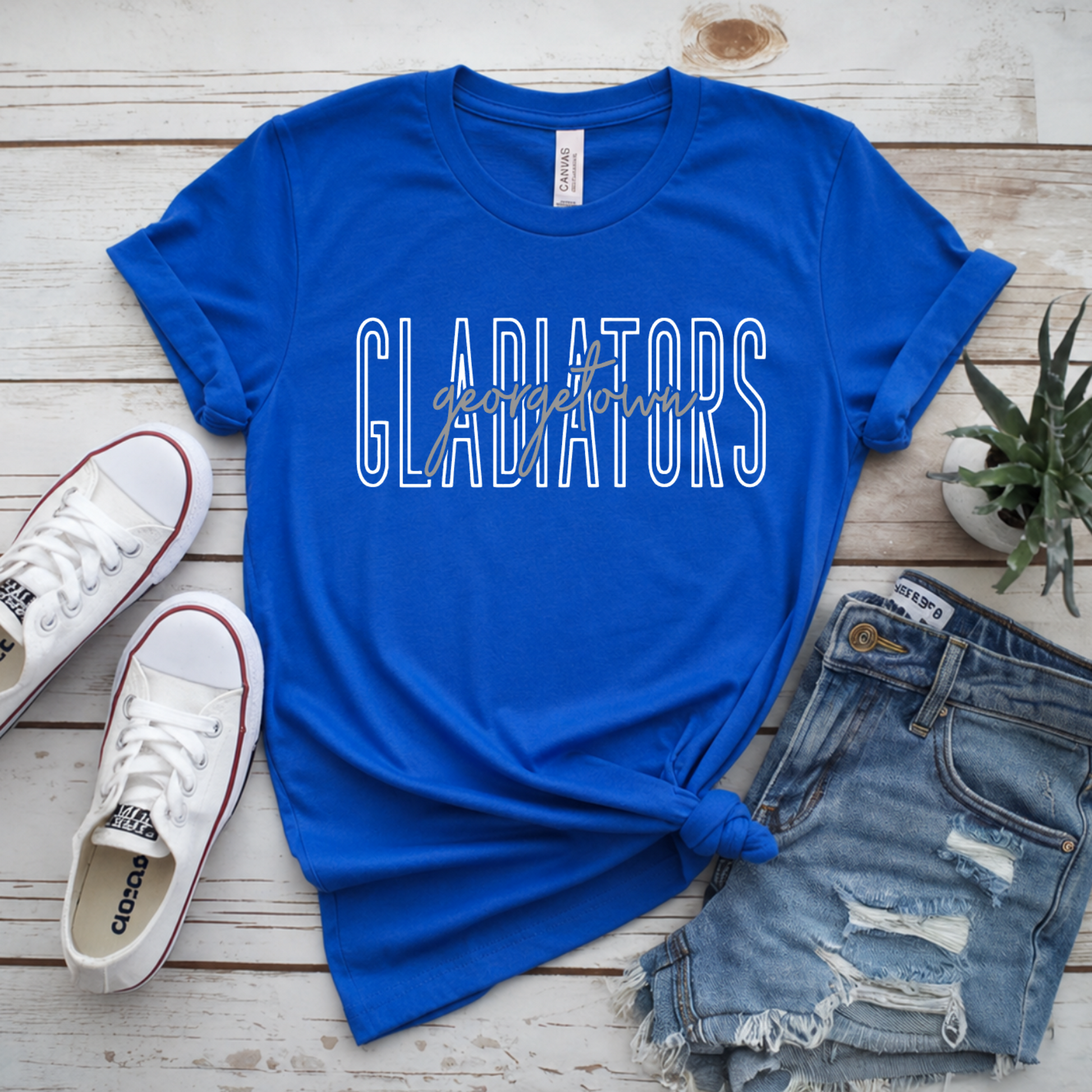 Georgetown Gladiators women’s royal blue spirit T-shirt with white outlined Gladiators lettering and Georgetown script design