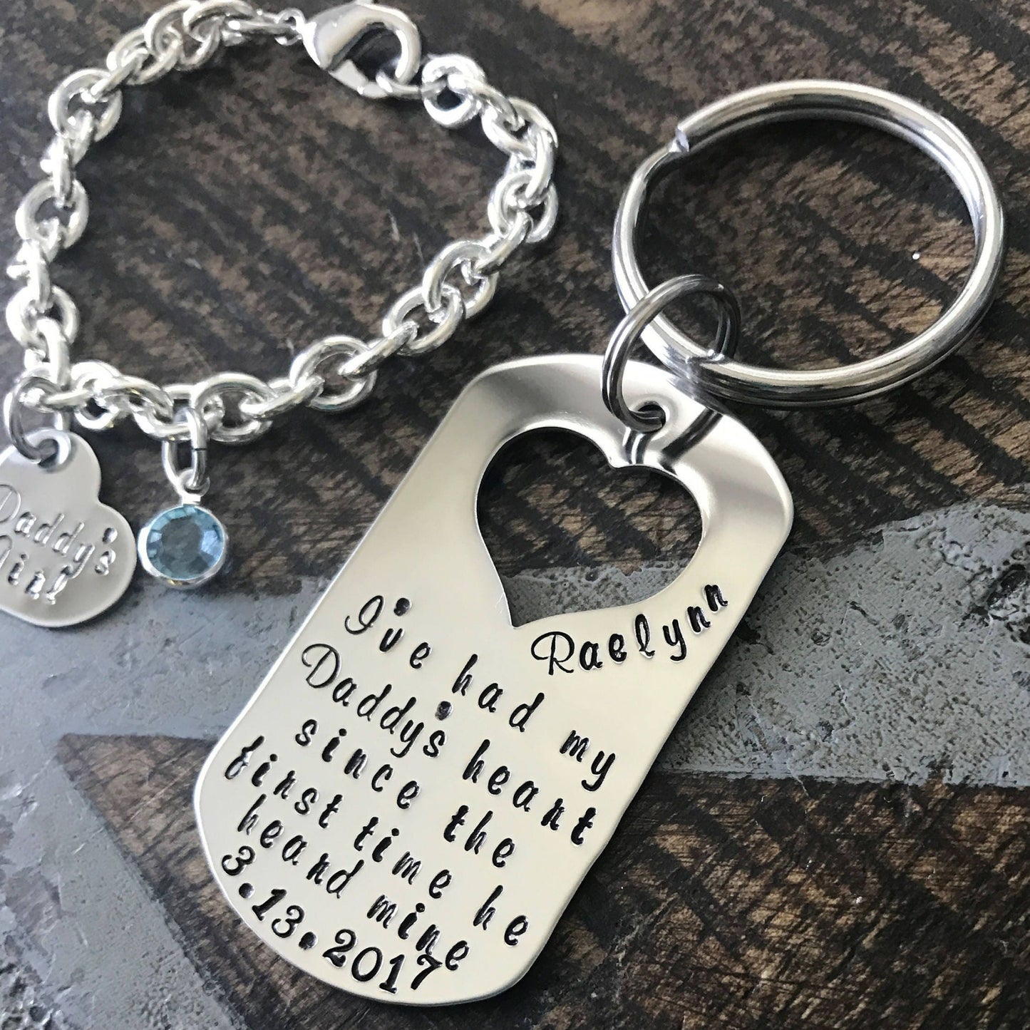 Silver keychain with engraved heart-shaped tag on a wooden surface
