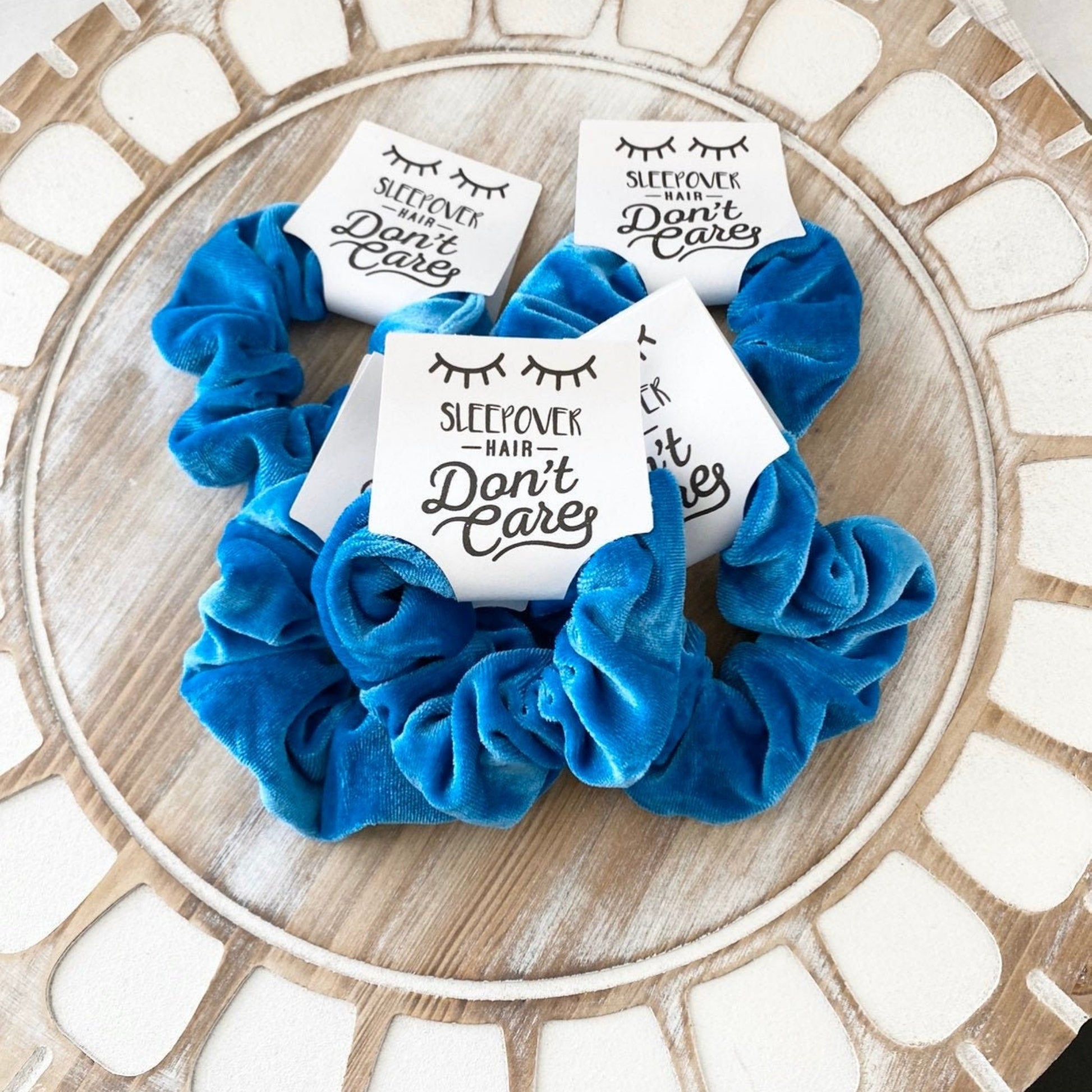 Blue scrunchie with 'Sleepover Hair Don't Care' stickers on a decorative plate.