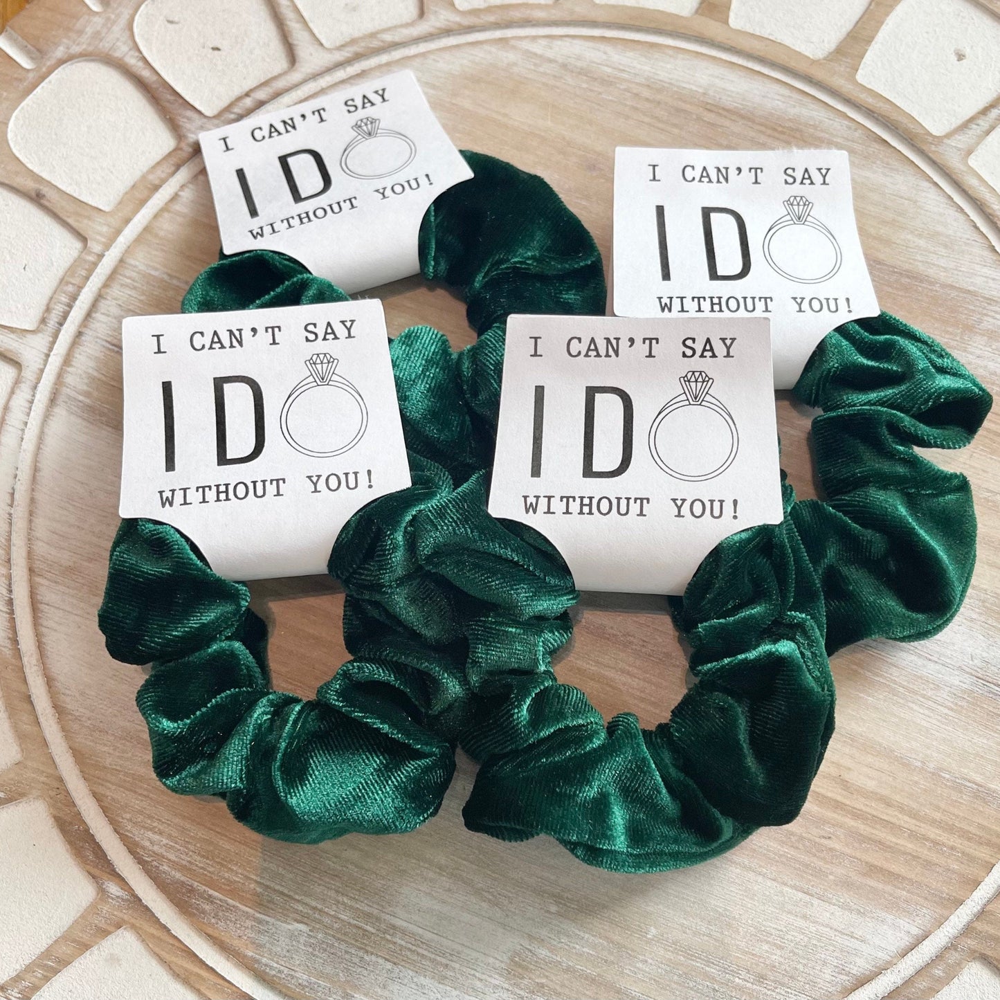 Green scrunchies with 'I can't say I do without you' cards on a textured surface