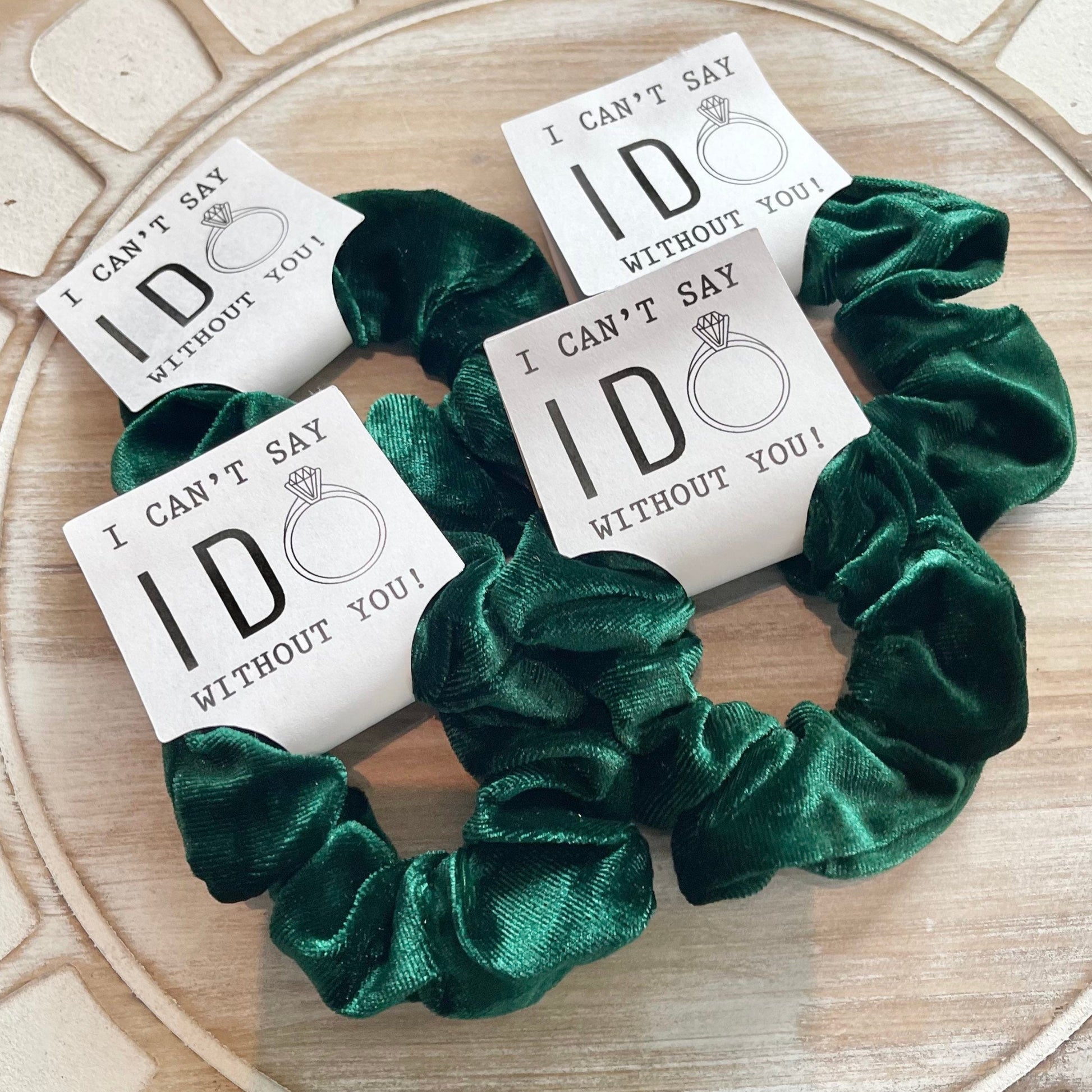 Green scrunchies with 'I can't say ID without you' cards on a wooden surface