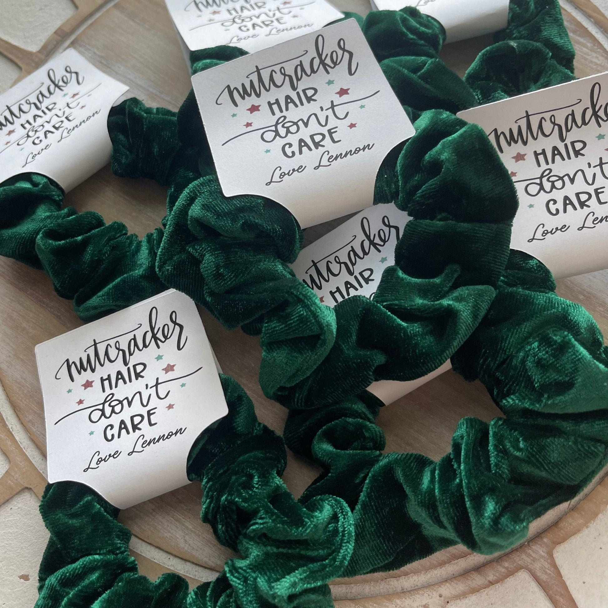 Green velvet scrunchies with 'Nuttercracker' labels on a textured surface
