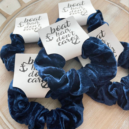 Blue scrunchies with white cards on a wooden surface