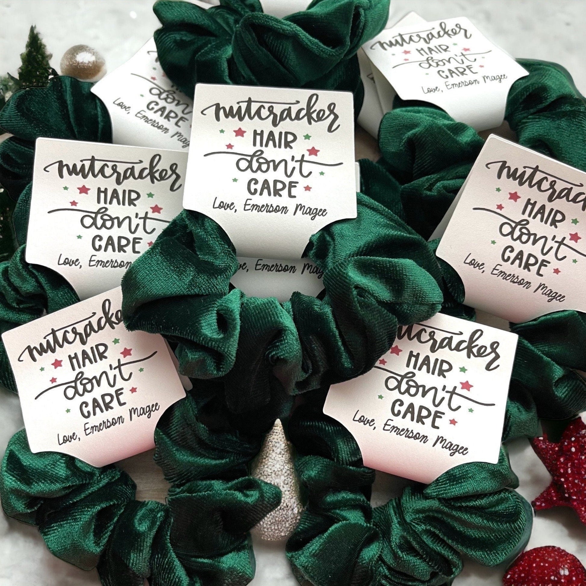 Green scrunchies with 'Nutcracker Hair Don't Care' labels on a white background