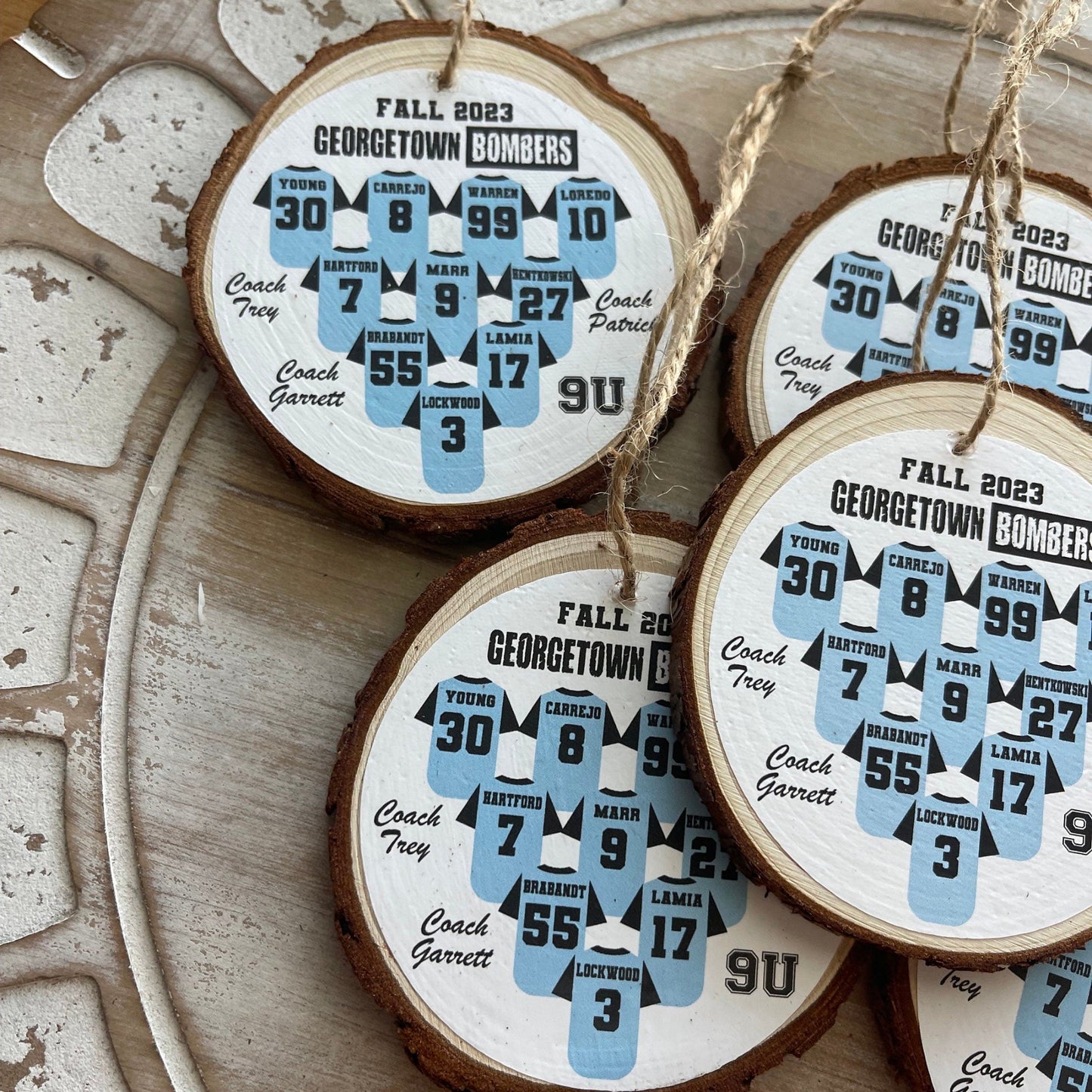Wooden ornaments with printed designs of sports jerseys on a decorative surface.