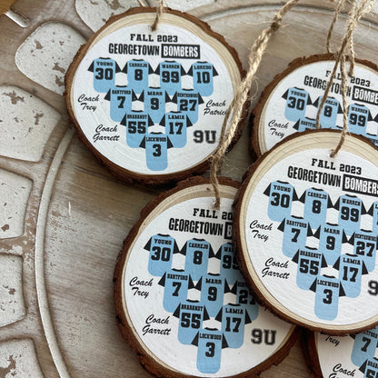Wooden ornaments with printed designs of sports jerseys on a decorative surface.