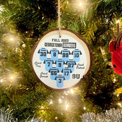Wooden ornament with numbers and text hanging on a Christmas tree