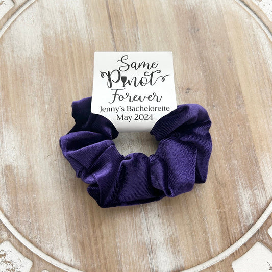 Purple scrunchie with a card on a wooden surface