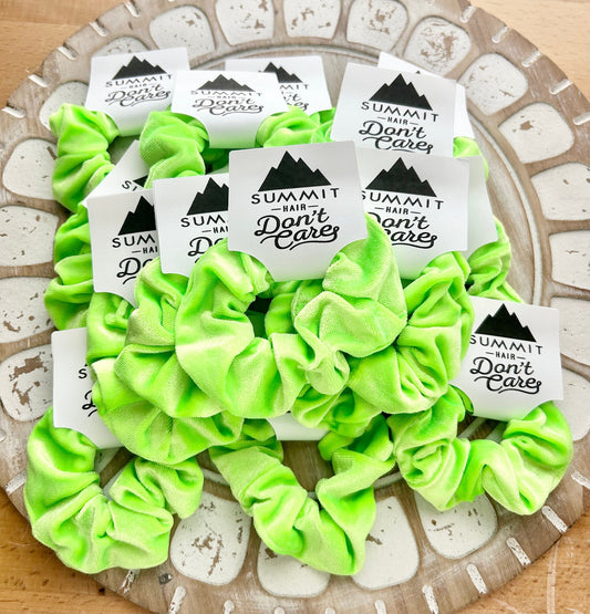 Green scrunchies with 'Summit Hair Don't Care' labels on a decorative plate.
