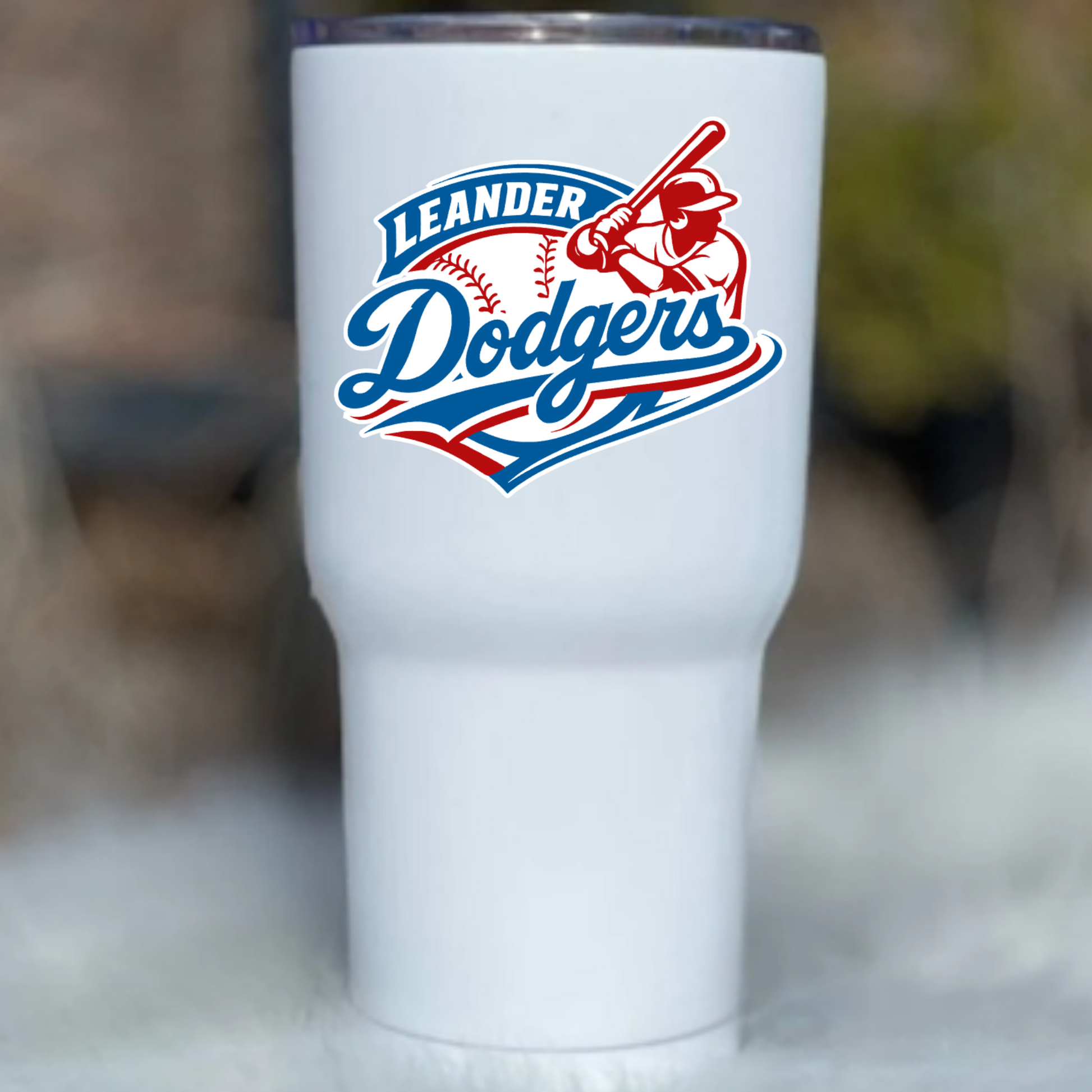 White tumbler with Leander Dodgers logo on a blurred background